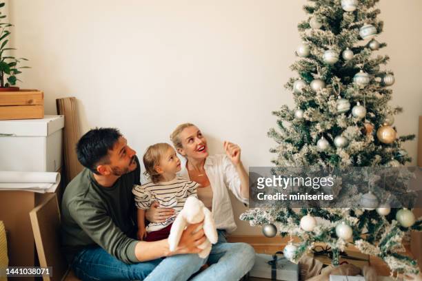 cheerful smiling family decorating home for christmas - homeowners decorate their houses for christmas stockfoto's en -beelden