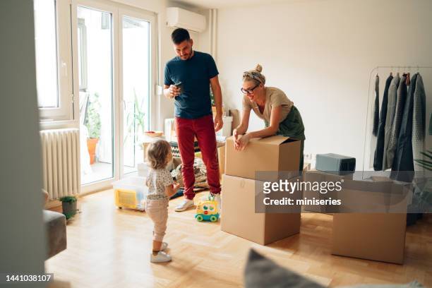 cheerful family moving in new home - 30-39 years stock pictures, royalty-free photos & images