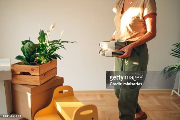 close up photo of woman hands holding green plates in new home - neat stockfoto's en -beelden
