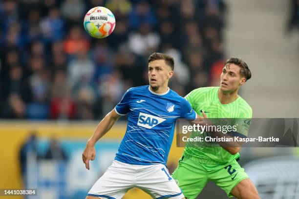 Christoph Baumgartner of TSG 1899 Hoffenheim is tackled by Kilian Fischer of VfL Wolfsburg during the Bundesliga match between TSG Hoffenheim and VfL...