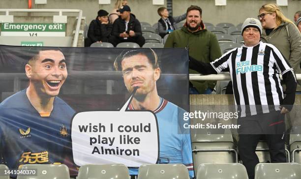 Flag held by a Newcastle fan shows Newcastle player Miguel Almiron and Manchester City player Jack Grealish prior to the Premier League match between...