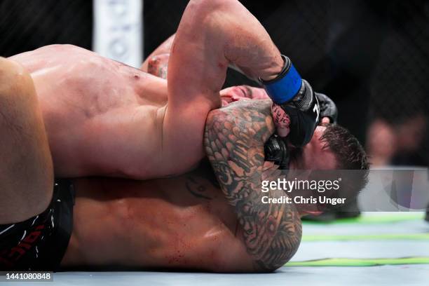 Dustin Poirier secures a rear choke submission against Michael Chandler in a lightweight bout during the UFC 281 event at Madison Square Garden on...
