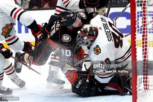 Jack Johnson and Arvid Soderblom of the Chicago Blackhawks push down Pavol Regenda of the Anaheim Ducks during the second period of a game at Honda...
