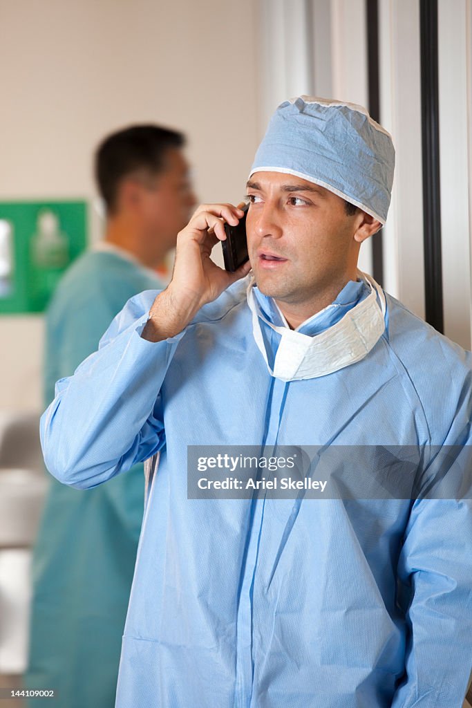 Hispanic doctor talking on cell phone in hospital