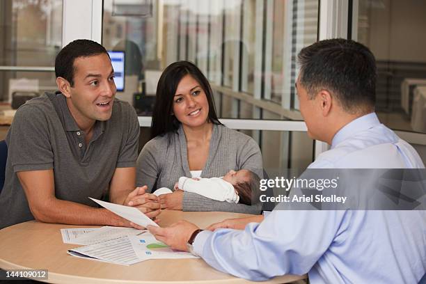 hispanic couple with baby talking to financial advisor - financial advisor with family stock pictures, royalty-free photos & images