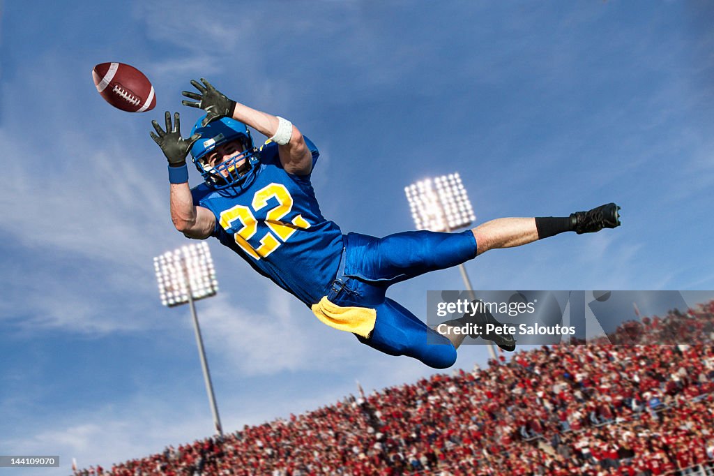 Caucasian football player catching ball