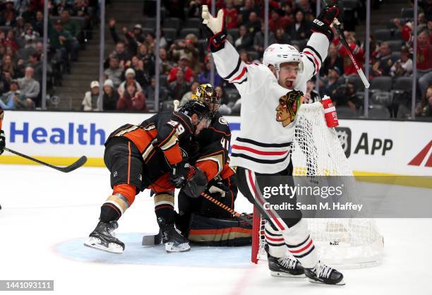 Dmitry Kulikov and Anthony Stolarz of the Anaheim Ducks attempt to stop a goal by Jarred Tinordi as Max Domi of the Chicago Blackhawks reacts during...