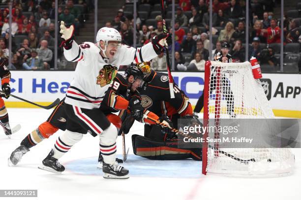 Dmitry Kulikov and Anthony Stolarz of the Anaheim Ducks attempt to stop a goal by Jarred Tinordi as Max Domi of the Chicago Blackhawks reacts during...