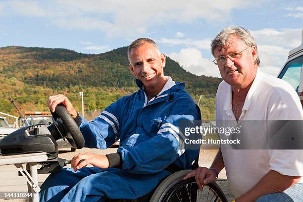 disability racer with spinal cord injury in wheelchair at driving simulator with his coach - paraplegic race stock pictures, royalty-free photos & images