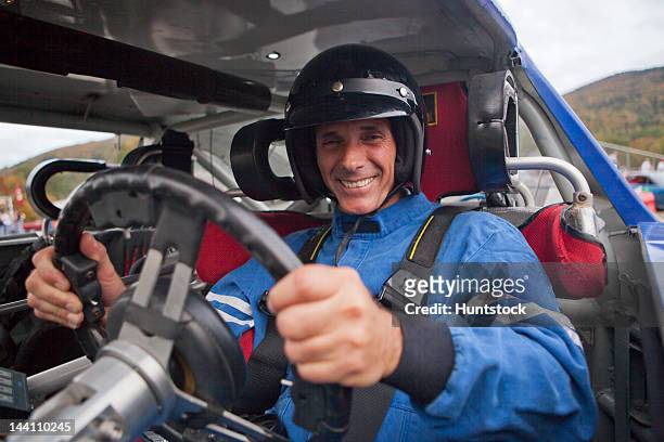 disabled race car driver with spinal cord injury in a modified car with removable steering wheel, gas and brake hand controls and push button automatic transmission - pilota di auto da corsa foto e immagini stock