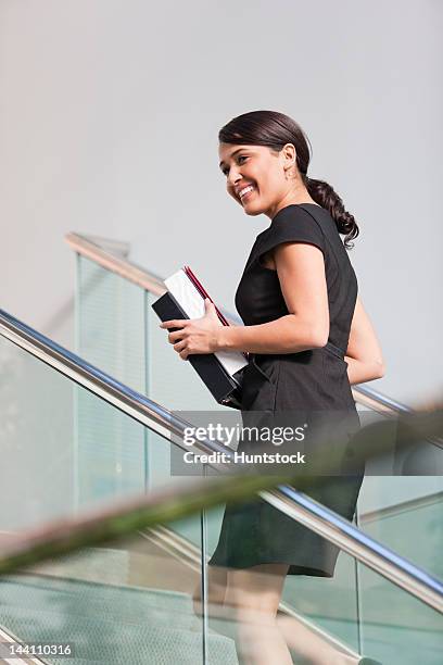 businesswoman going up stairs of office building - pardo brazilian stock pictures, royalty-free photos & images