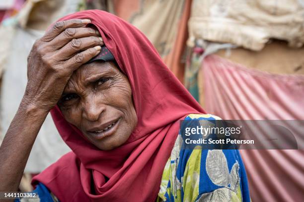 Somali mother Nunney Hassanow Abdyow holds her head in her hand in front of her makeshift hut in the Hagarey Hoos Tumal camp, as Somalis displaced by...