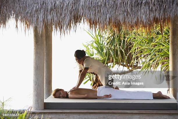 mulher com massagem no tropical sala - telhado de palha imagens e fotografias de stock