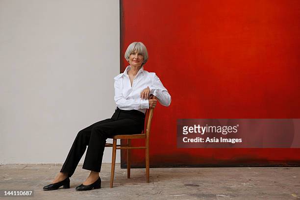 woman with painting - sitting in a chair stockfoto's en -beelden