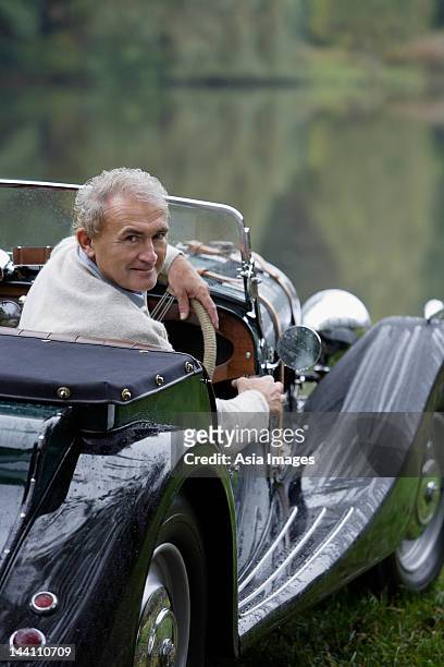 senior man sitting in antique car - antique car bildbanksfoton och bilder