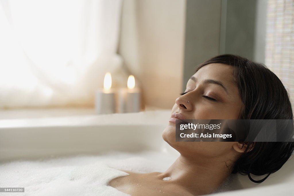 Woman reclining in bathtub