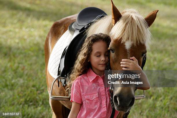 young girl hugging nose of pony - girl hold nose stock pictures, royalty-free photos & images