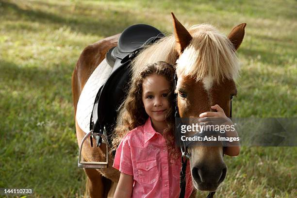young girl hugging nose of pony - girl with brown hair stock pictures, royalty-free photos & images