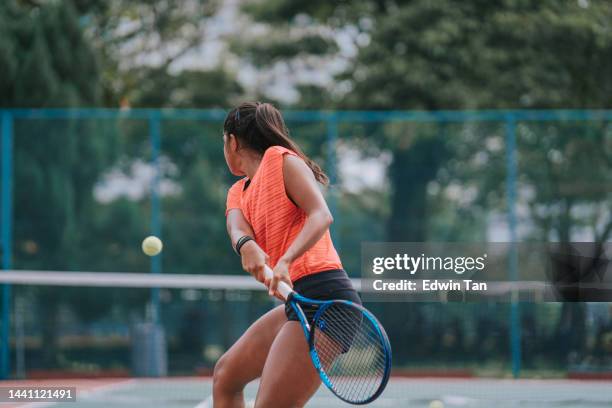 joueuse de tennis indienne d’origine asiatique servant le ballon s’entraînant sur un court de tennis avec les conseils d’un entraîneur - balle de tennis photos et images de collection