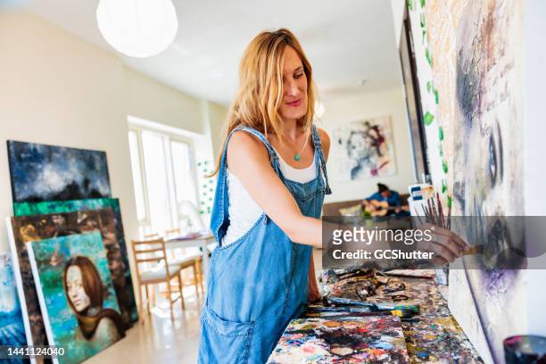 künstlerin arbeitet in ihrem atelier - female artist painting stock-fotos und bilder