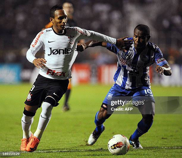 Liedson of Brazil´s Corinthians, vies for the ball with Oscar Bagui of Ecuador´s Emelec, during their 2012 Copa Libertadores football match held at...