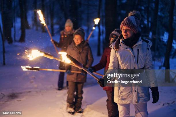 familienspaziergang im winterwald mit fackeln - fackel stock-fotos und bilder