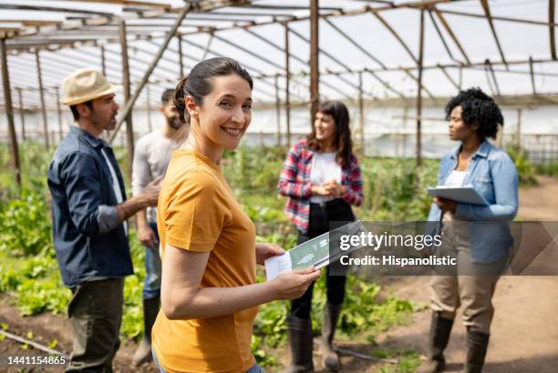 woman learning about organic farming at a community garden - farmworkers stock pictures, royalty-free photos & images