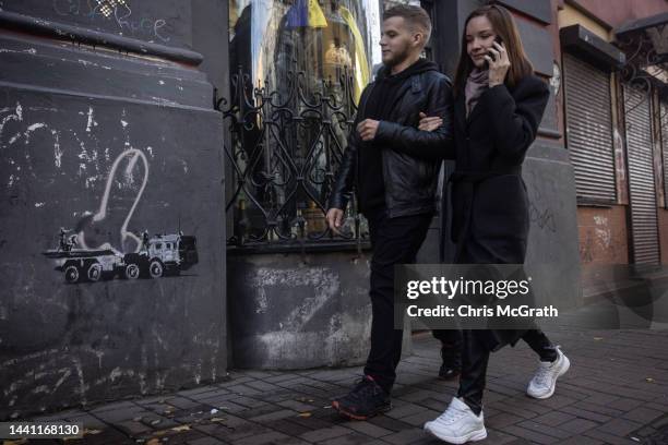 People walk past a street art mural done in the signature style of famous street artist Banksy, although it has not yet been confirmed by the artist...