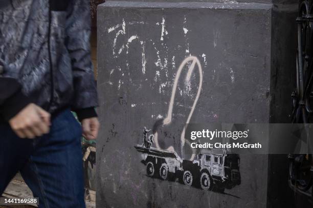 Man walks past a street art mural done in the signature style of famous street artist Banksy, although it has not yet been confirmed by the artist on...