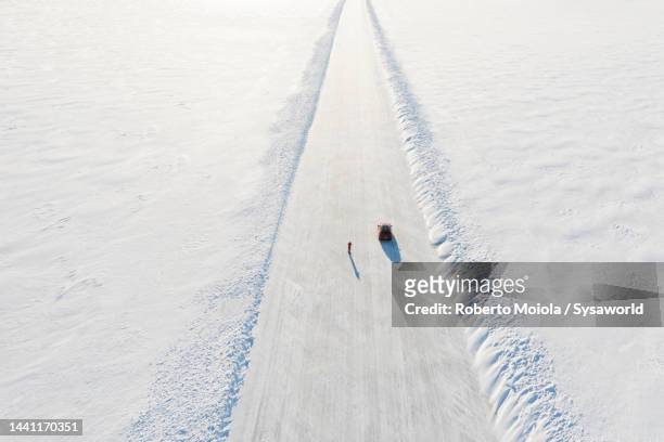 overhead view of person with car on empty ice road - crossing the road stock pictures, royalty-free photos & images