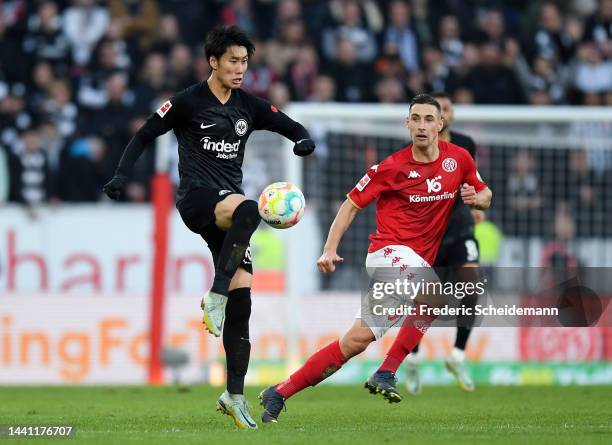 Daichi Kamada of Eintracht Frankfurt is challenged by Dominik Kohr of 1.FSV Mainz 05 during the Bundesliga match between 1. FSV Mainz 05 and...