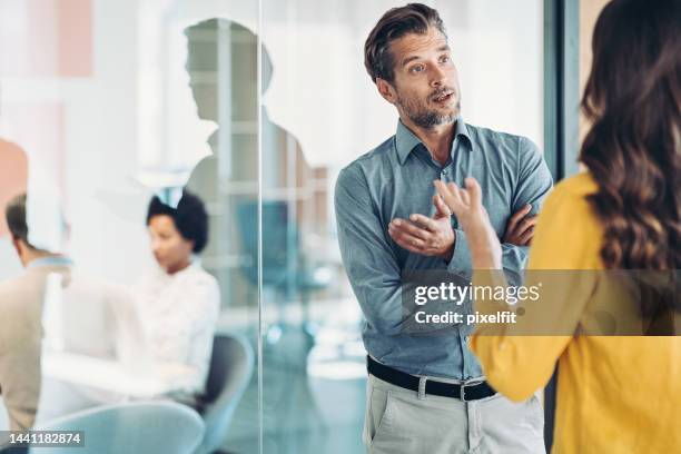 diskussion zwischen geschäftspartnern - boss over shoulder stock-fotos und bilder