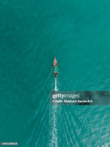 drone image showing a traditional fishing boat on the indian ocean, phuket, thailand - longtail boat stock pictures, royalty-free photos & images