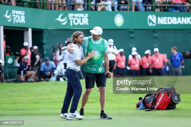 Tommy Fleetwood of England celebrates after winning the Nedbank Golf Challenge with his caddie on the 18th hole during Day Four of the Nedbank Golf...