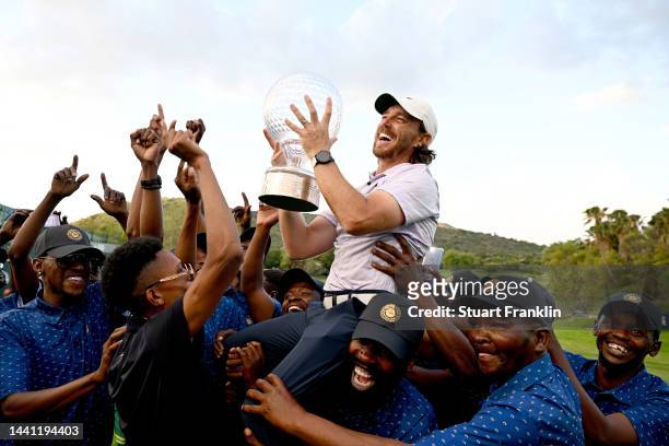 Tommy Fleetwood of England is thrown to the air by the volunteers with the Nedbank Golf Challenge trophy after winning the Nedbank Golf Challenge on...