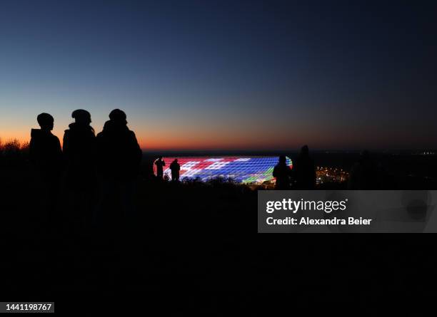 People look at the illuminated Allianz Arena stadium during the NFL match between Seattle Seahawks and Tampa Bay Buccaneers at Allianz Arena on...