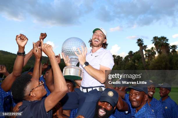 Tommy Fleetwood of England is thrown to the air by the green keepers with the Nedbank Golf Challenge trophy after winning the Nedbank Golf Challenge...