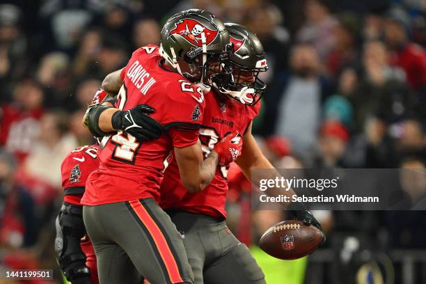 Carlton Davis III embraces Anthony Nelson of the Tampa Bay Buccaneers in the third quarter during the NFL match between Seattle Seahawks and Tampa...