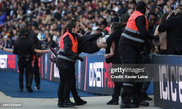 Femen activist is ejected by security during the Ligue 1 match between Paris Saint-Germain and AJ Auxerre at Parc des Princes on November 13, 2022 in...