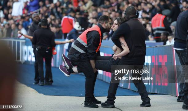 Femen activist is ejected by security during the Ligue 1 match between Paris Saint-Germain and AJ Auxerre at Parc des Princes on November 13, 2022 in...