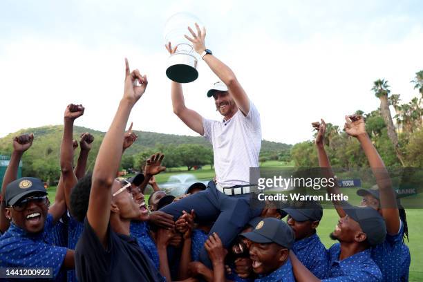 Tommy Fleetwood of England is thrown to the air by the green keepers with the Nedbank Golf Challenge trophy after winning the Nedbank Golf Challenge...