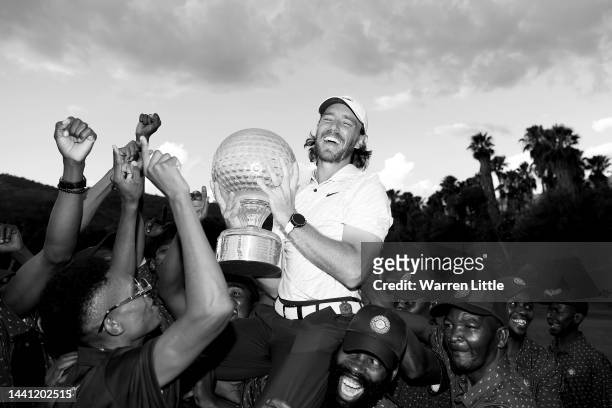 Tommy Fleetwood of England is thrown to the air by the green keepers with the Nedbank Golf Challenge trophy after winning the Nedbank Golf Challenge...