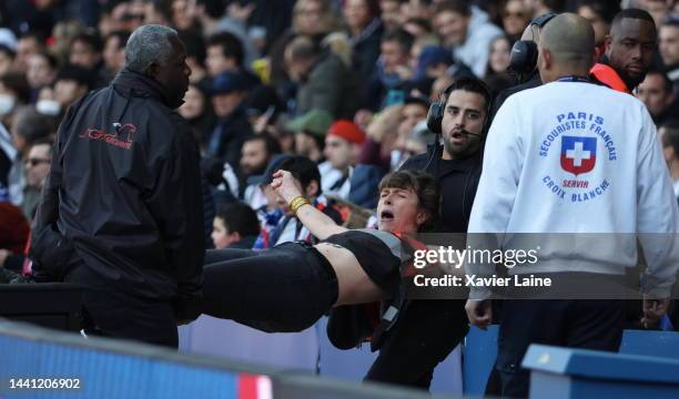 Femen activist is ejected by security during the Ligue 1 match between Paris Saint-Germain and AJ Auxerre at Parc des Princes on November 13, 2022 in...