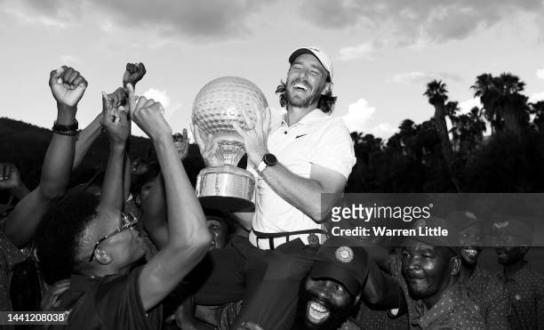 Tommy Fleetwood of England is held aloft by the green keepers after winning the Nedbank Golf Challenge at Gary Player CC on November 13, 2022 in Sun...