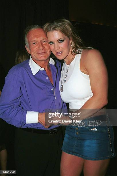 Playboy founder Hugh Hefner poses with former wrestler, Joanie Laurer, during the Tongue Magazine Fall 2002 Issue release party featuring covergirl,...