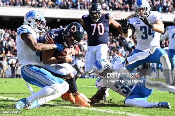 Justin Fields of the Chicago Bears runs over DeShon Elliott of the Detroit Lions while scoring a touchdown during the second quarter at Soldier Field...