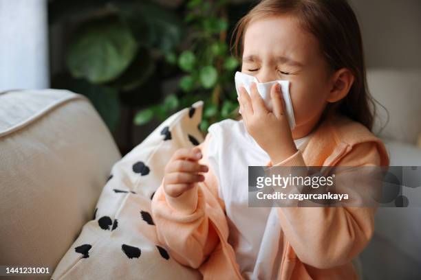 little girl gets cold and blows her nose at home. - covering nose stock pictures, royalty-free photos & images