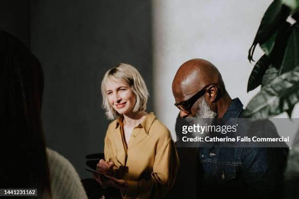 conceptual image of a man and a woman sitting side-by-side in a sunny, modern environment. - enterprise stock pictures, royalty-free photos & images