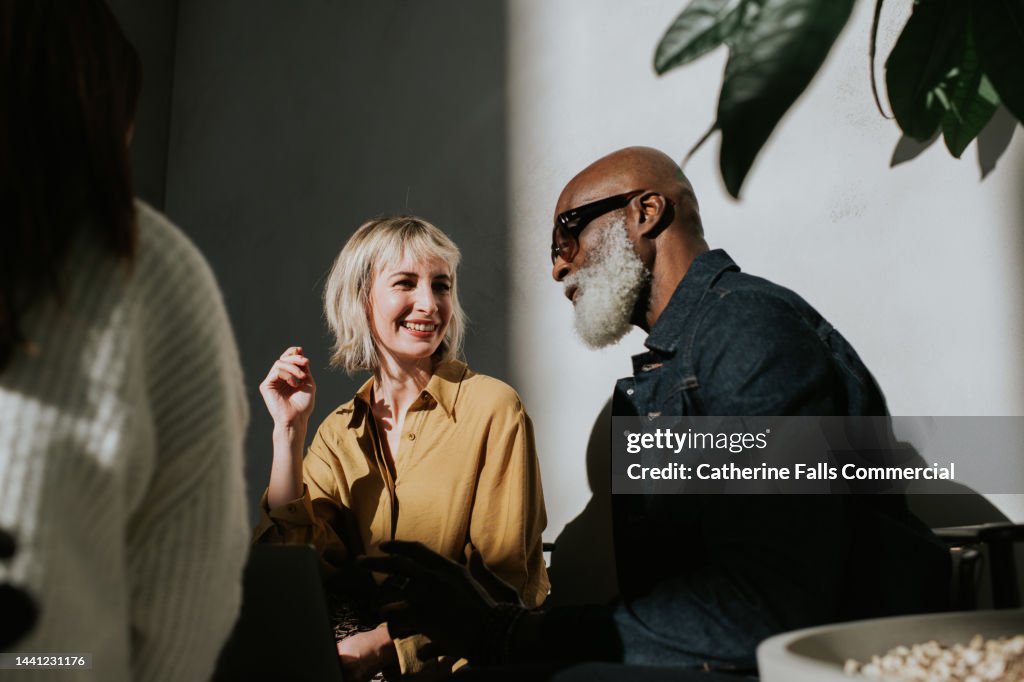 Conceptual image of a man and a woman sitting side-by-side in a sunny, modern environment.