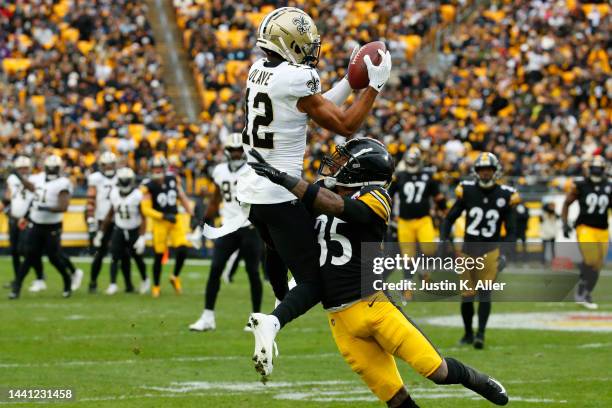 Chris Olave of the New Orleans Saints catches the ball while being guarded by Arthur Maulet of the Pittsburgh Steelers during the first half of the...